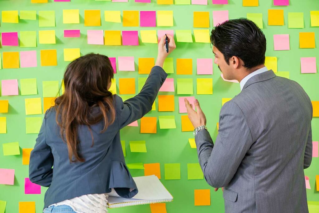 International leadership Training where two people write on sticky notes